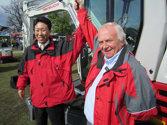 JUST CHAMPION: Jim Mulligan celebrates his award on the stand with Tomonori Tamaru, managing director of Takeuchi MFG (UK) Ltd.